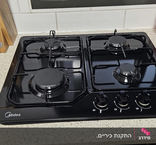 כיריים גז שחורות על משטח מטבח בהיר